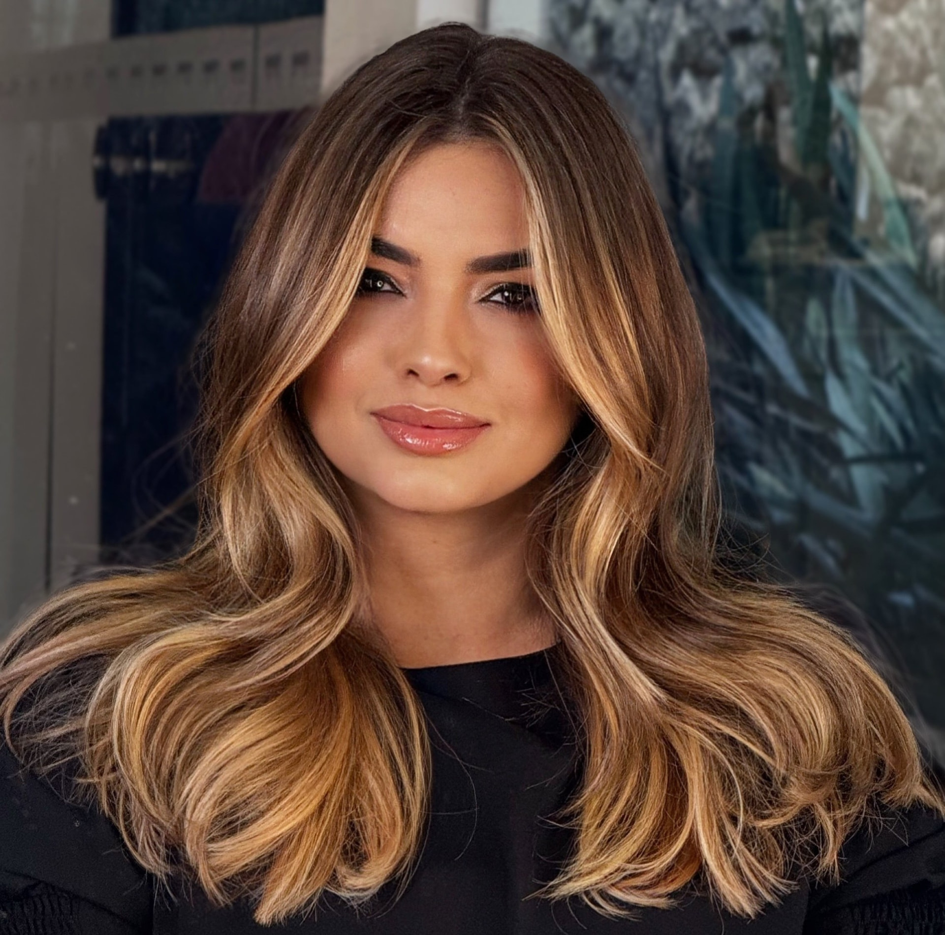 Morena iluminada com mechas douradas e camadas modeladas